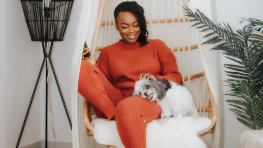 Professional Organizer Atlanta, GA Kenika Williams, black woman sitting in chair petting a small dog